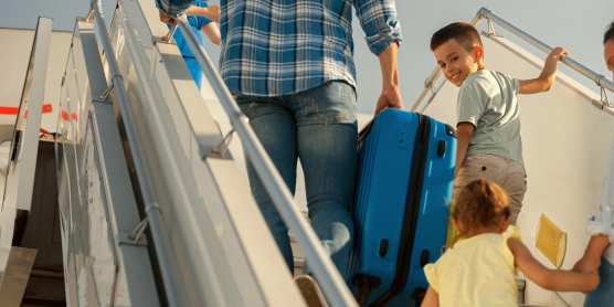 Familie mit Kindern steigt ins Flugzeug – Symbolbild für internationalen Umzug