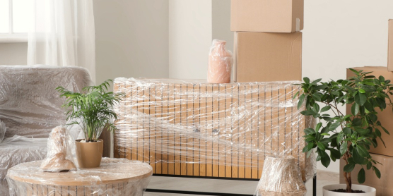 Ein Wohnraum mit verpackten Möbeln und gestapelten Umzugskartons. Symbolisiert den Relocation Service für Privatpersonen.