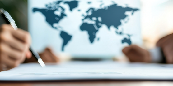 Geschäftsleute bei der Planung internationaler Standorte mit Weltkarte im Hintergrund.