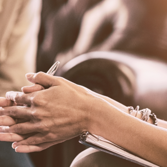 Zwei Frauen im Gespräch auf einem Ledersofa – psychologische Beratung zum Thema Umzugspsychologie.