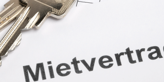 Schlüssel und Mietvertrag auf Tisch – Symbolbild für eine Wohnungsübergabe bei Ein- oder Auszug