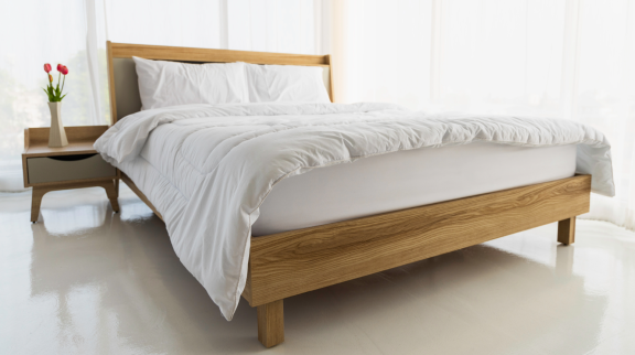 Modernes Schlafzimmer mit hellem Holzrahmen – Beispiel für fertig aufgebautes Bett