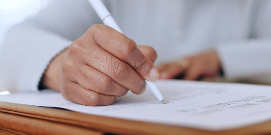 Hand signing apartment application – accessible and user-friendly support for filling out housing documents