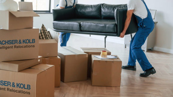 Umzugshelfer tragen Sofa und Kartons – professioneller Privatumzug mit DACHSER & KOLB