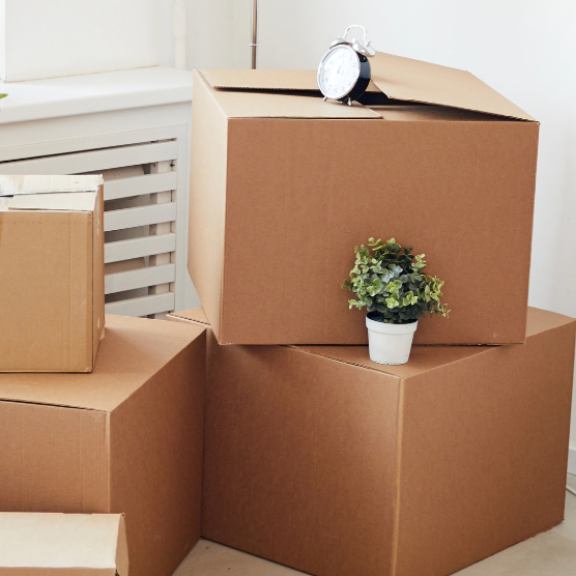 Mehrere gepackte Umzugskartons unterschiedlicher Größen in einem hellen Raum, bereit für den Umzug.