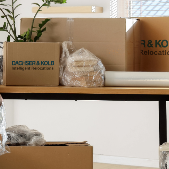 Büroraum mit verpackten Möbeln und Kartons, professionelle Emballage.