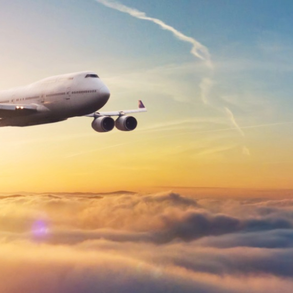 Airline-Flugzeug über den Wolken bei Sonnenaufgang