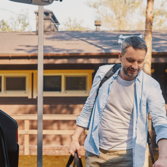 Familie packt Koffer in das Auto. Symbol für einen Umzug oder eine Reise mit Relocation Service für Privatpersonen.